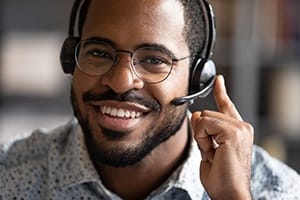 person smiling and taking a call on a headset